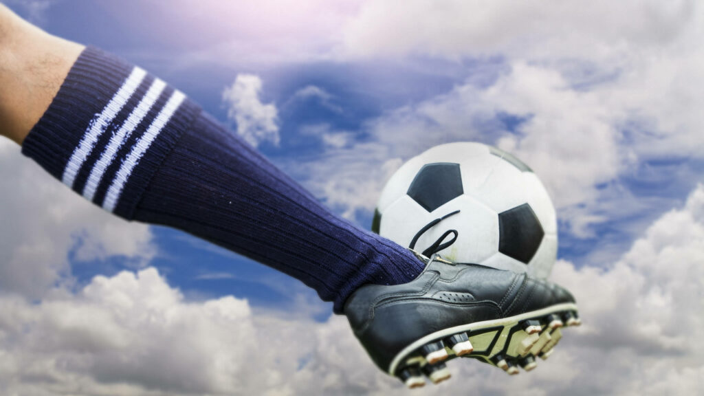 Powerful Kick propels a Soccer Ball across a Vibrant 2560x1440 Pitch Wallpaper
