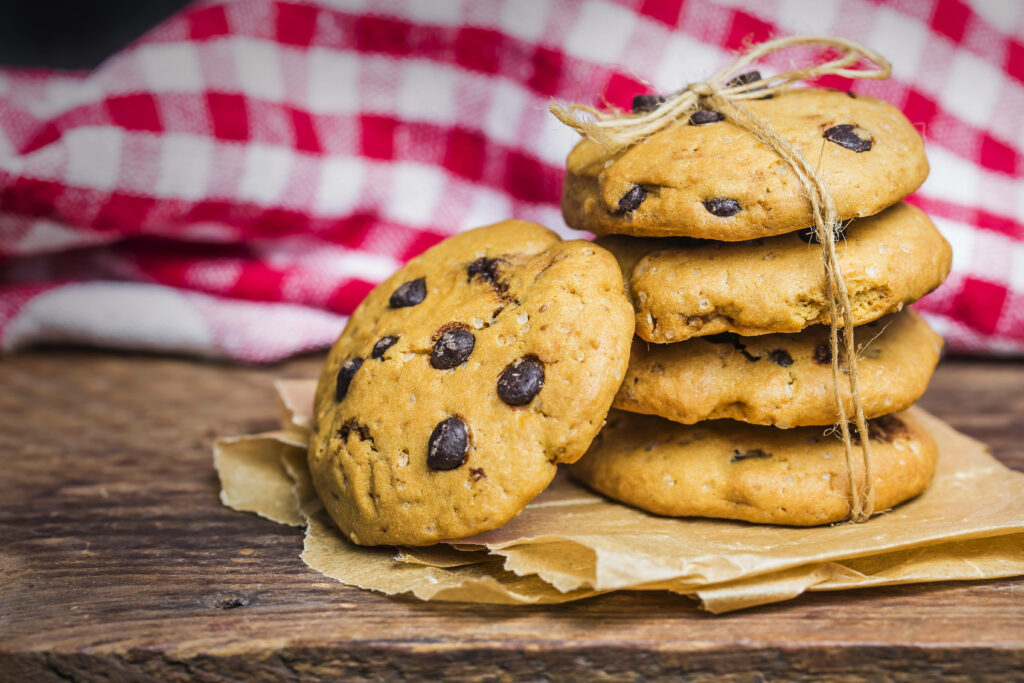 Composition of Tempting Chocolate Chip Cookies on a Delicate Parchment Wallpaper