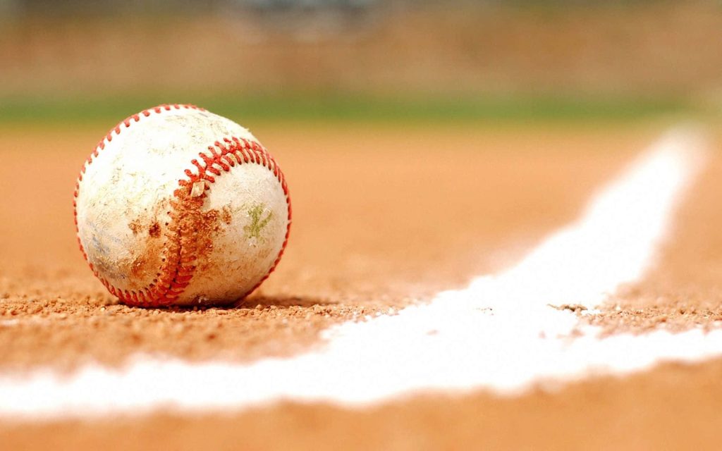 Close-up of a scuffed baseball on clay infield near foul line high-definition sports wallpaper background