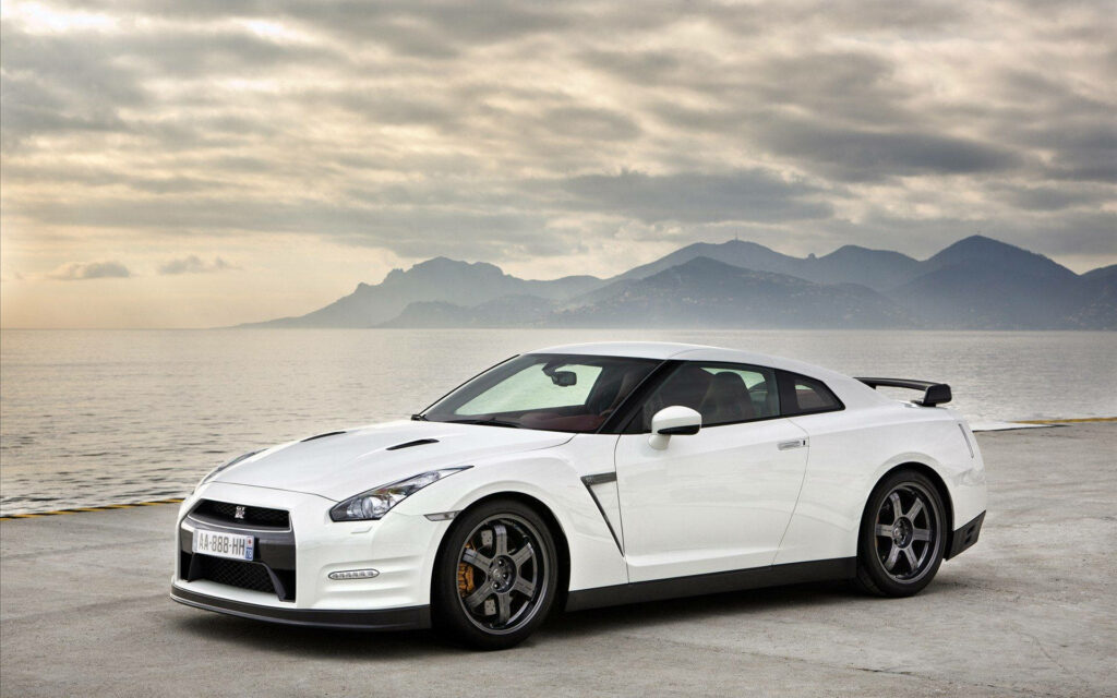 Shoreline Cruiser: A White Nissan GTR Car Takes on the Beach Wallpaper