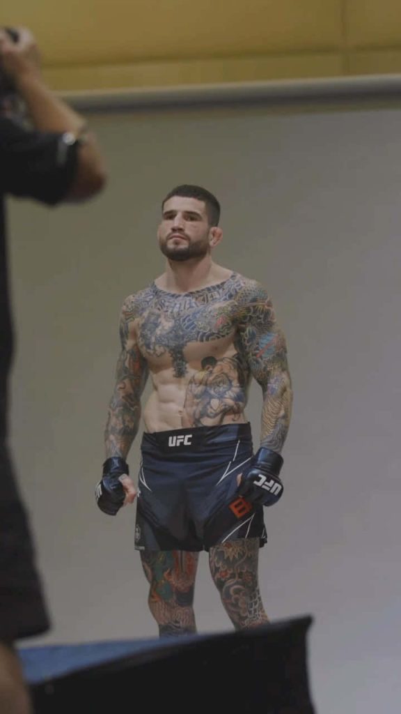 UFC welterweight Sean Brady intense portrait with UFC gloves and shorts on studio background Wallpaper