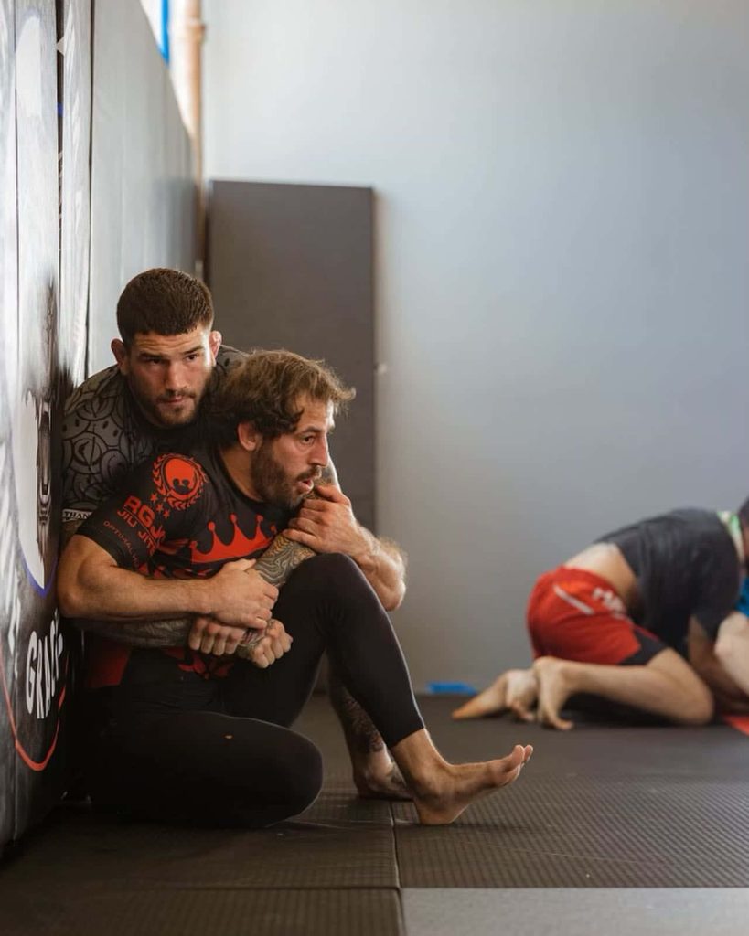 Sean Brady applies back control on Kody Hamrah in intense BJJ training gym scene wallpaper