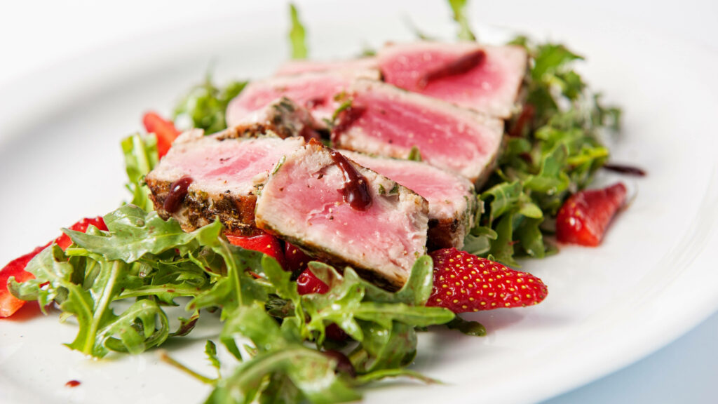 Vibrant plate with seared steak slices arugula and fresh berries colorful culinary wallpaper
