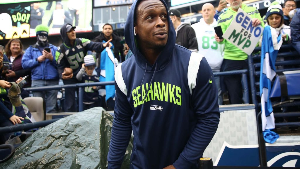 Seattle Seahawks quarterback Geno Smith in navy hoodie walking past fans with MVP sign wallpaper