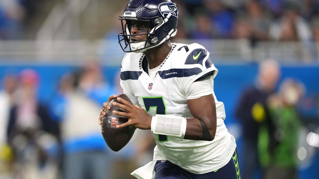 Seattle Seahawks quarterback Geno Smith in white jersey focused holding football NFL wallpaper