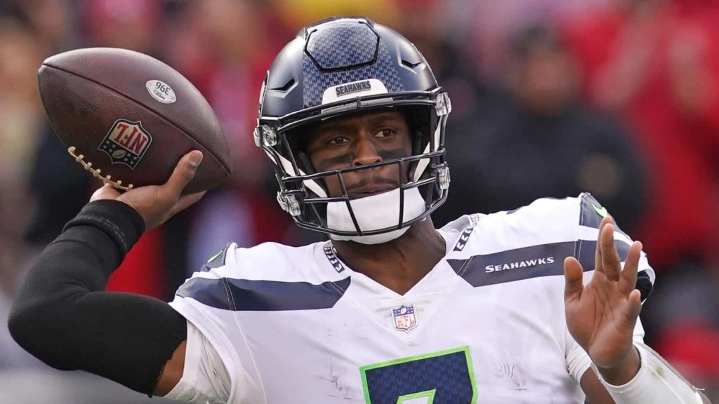 Seattle Seahawks quarterback Geno Smith mid-pass intense action NFL wallpaper background