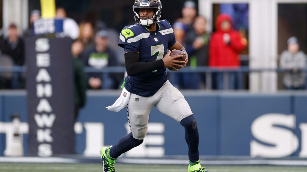 Seattle Seahawks quarterback Geno Smith in navy neon green uniform mid-play NFL action wallpaper