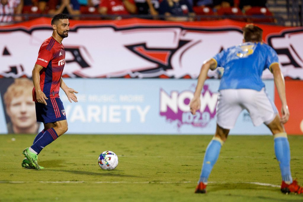 FC Dallas midfielder Sebastian Lletget dribbling past defender on green pitch during MLS match Wallpaper