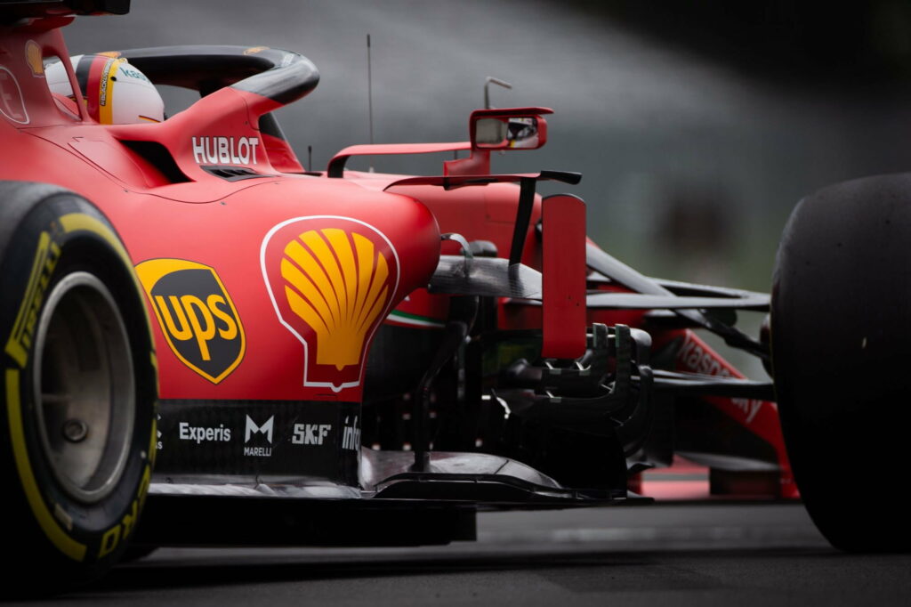 Ferrari F1 race car in motion with Black Lives Matter helmet sharp close-up on blurred track Wallpaper