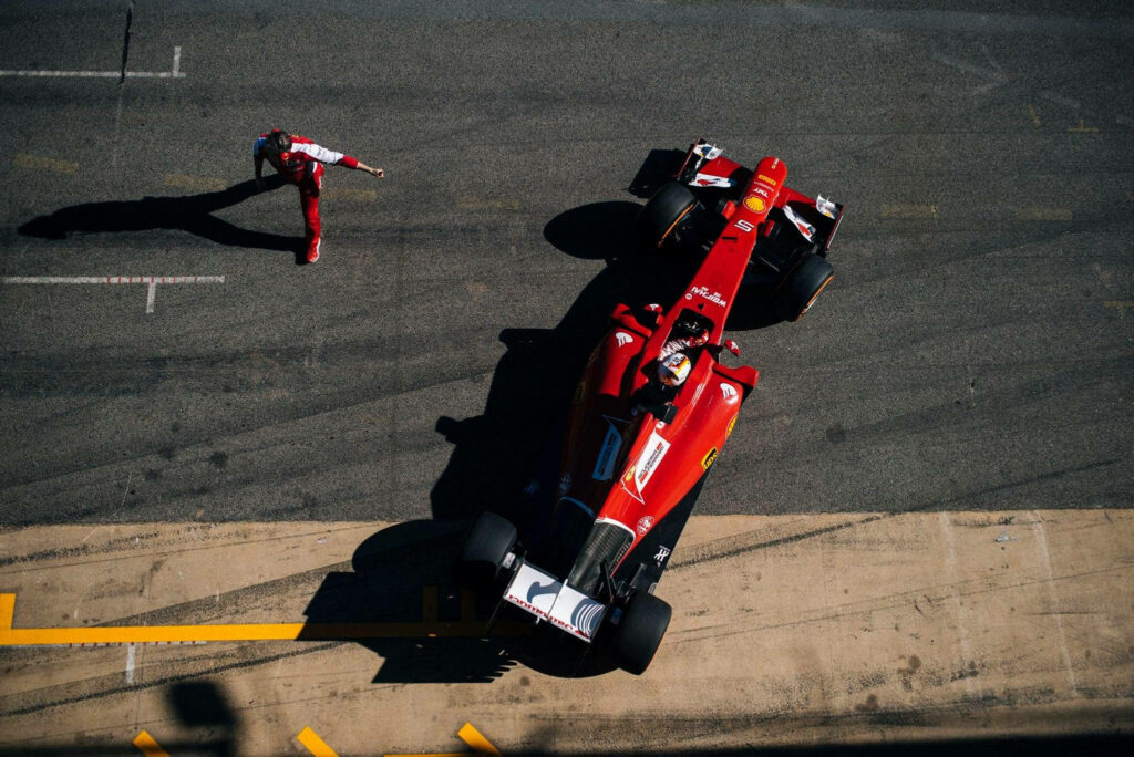 Marveling at Sebastian Vettel's Spectacular Stroll alongside a Formula One Machine Wallpaper