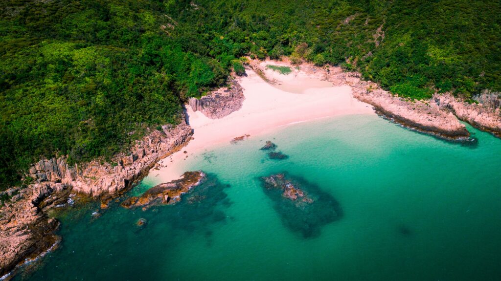 Aerial view of secluded island beach with lush forest sandy shores and turquoise ocean waters Wallpaper