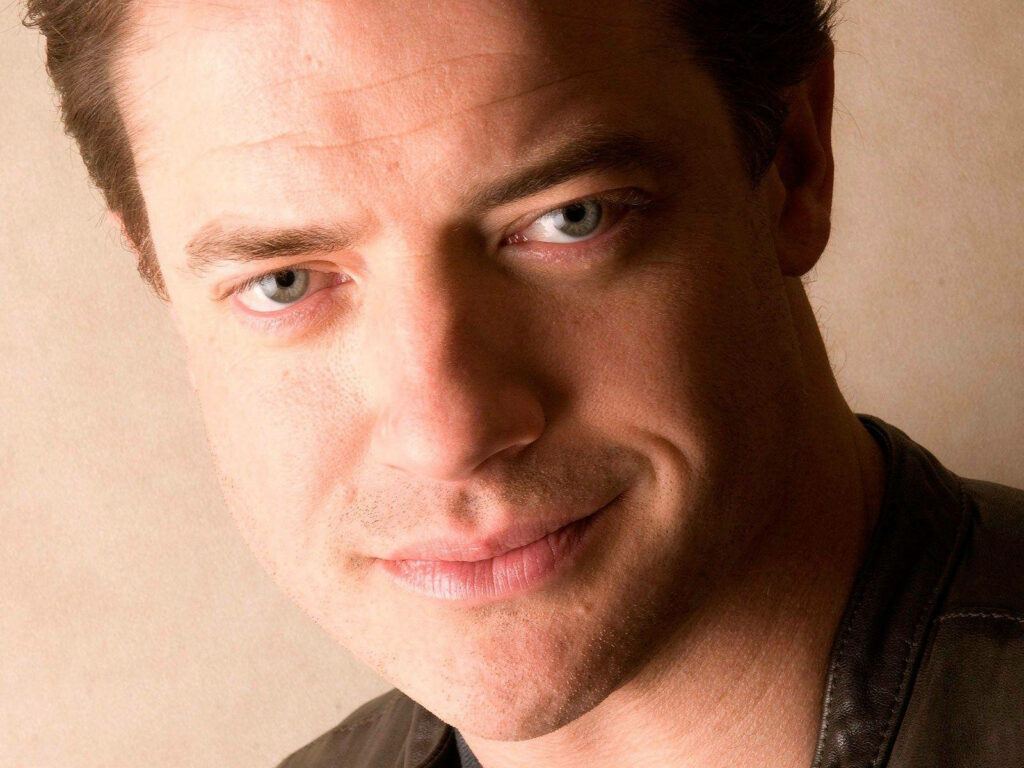 Close-up portrait of Brendan Fraser with captivating blue eyes and warm beige background wallpaper