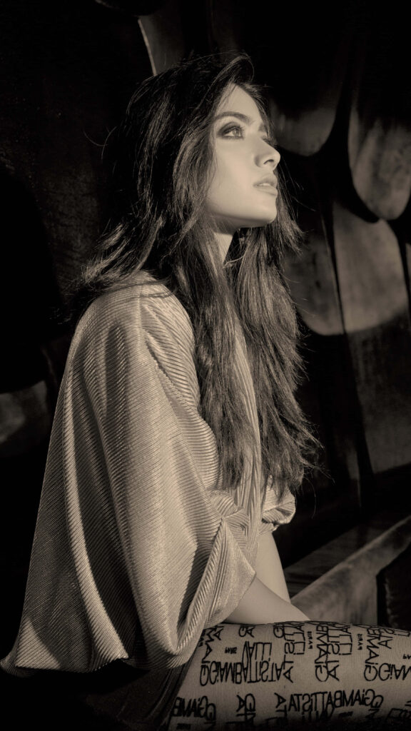 A Captivating Portrait of Indian Actress Rashmika Mandanna in Sepia Tone, Embracing Natural Beauty with Flowing Hair and Unique Stocking Style Wallpaper