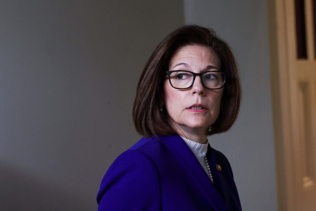 Senator Catherine Cortez Masto in deep blue blazer and glasses at professional conference setting Wallpaper