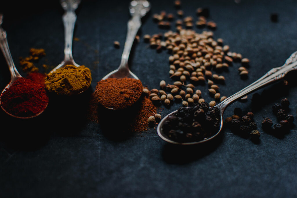 Bursting Flavors: A Macro View of Multifarious Cooking Spices Amidst Earthy Backdrop Wallpaper