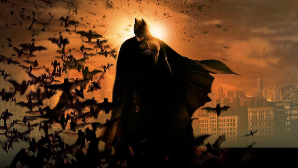 Batman silhouette with bats flying over glowing sepia cityscape cinematic moody wallpaper background