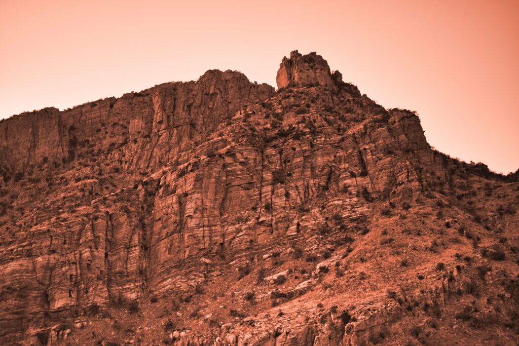 Sepia toned rocky mountain landscape with rugged stone formations and textured natural relief Wallpaper
