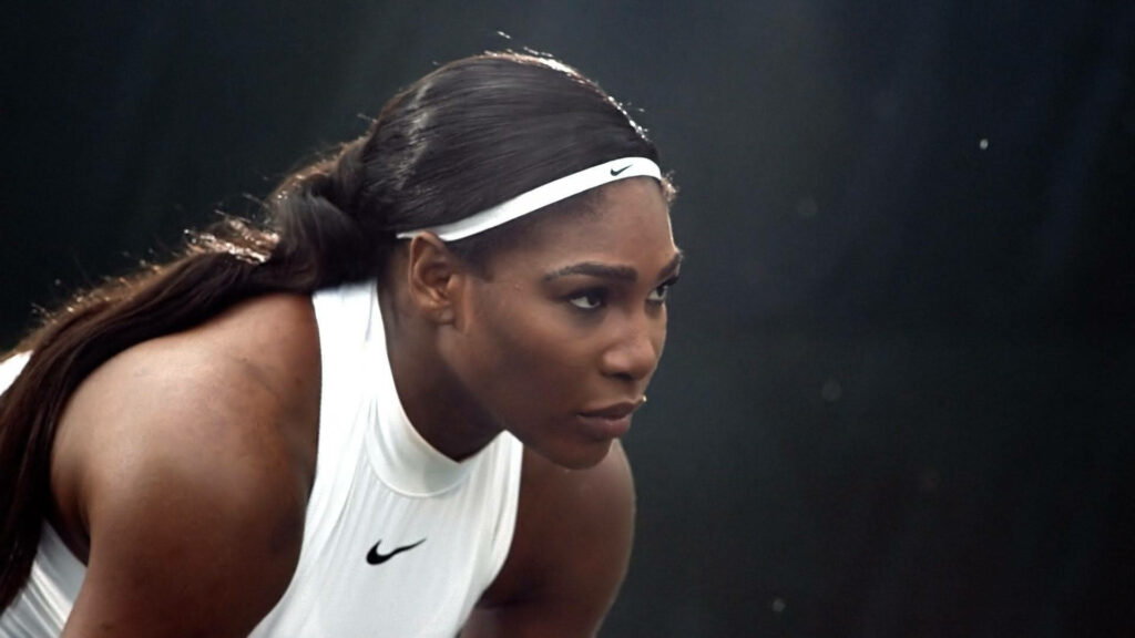 Serena Williams focused on court displaying athletic strength and champion spirit wallpaper background