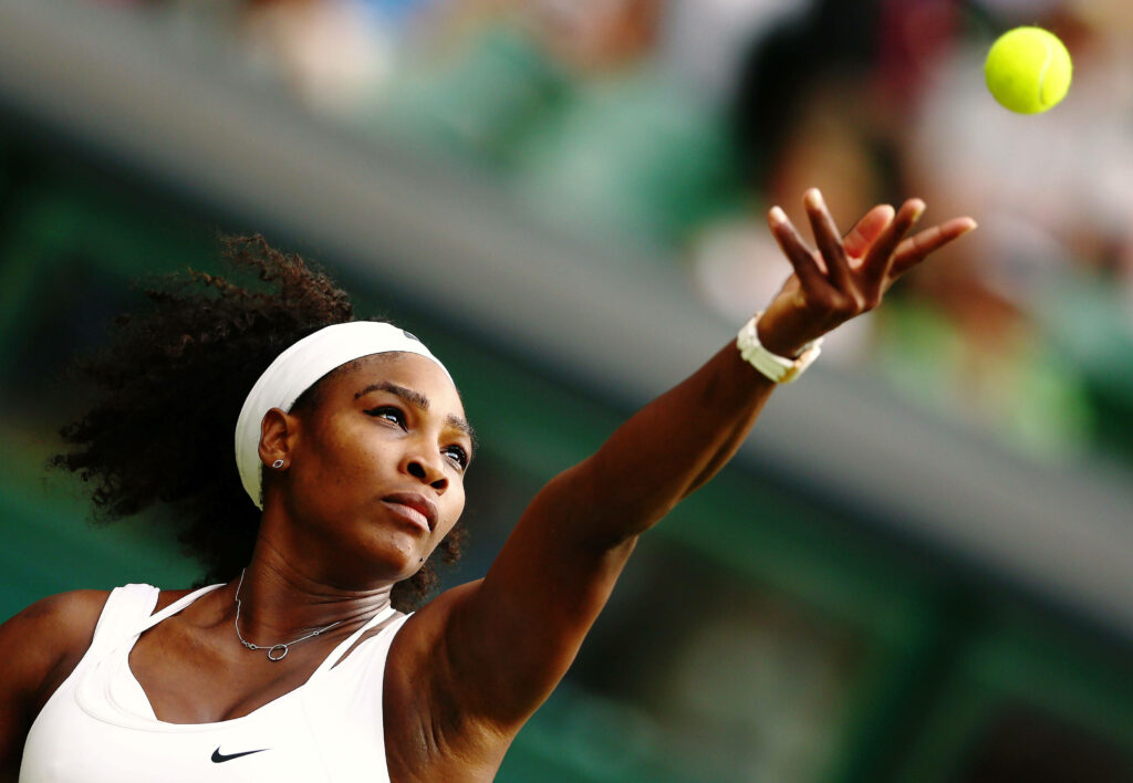 Serena Williams intense tennis serve focus showing athleticism determination dynamic wallpaper