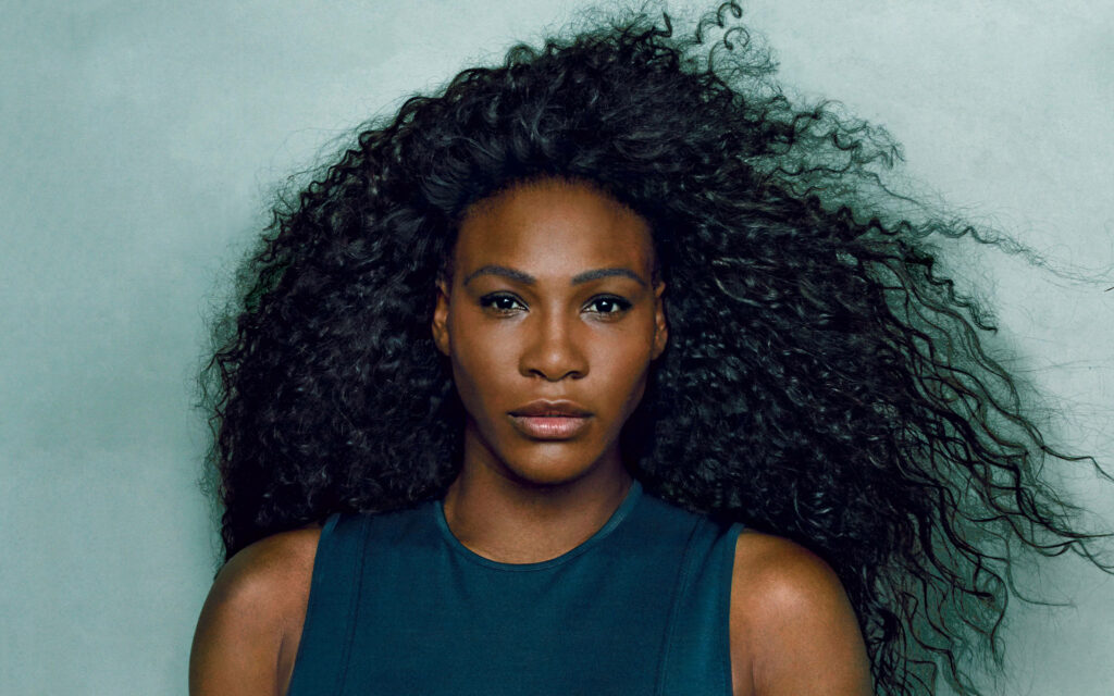 Serena Williams confident with natural curls against simple background wallpaper background