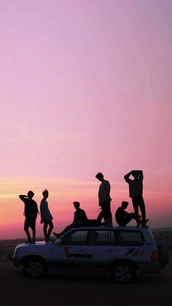 Breathtaking BTS Silhouette Against a Pink Sunset Skyline: A Captivating Phone Background Wallpaper