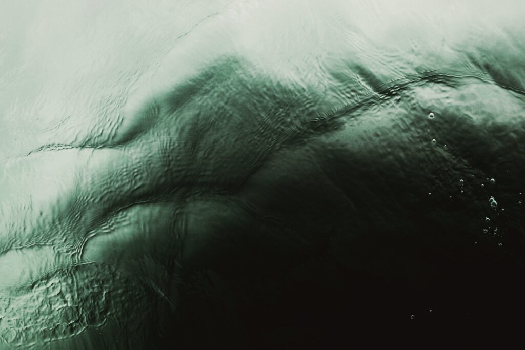 Abstract wallpaper with serene green and black water ripples and bubbles for calming backgrounds