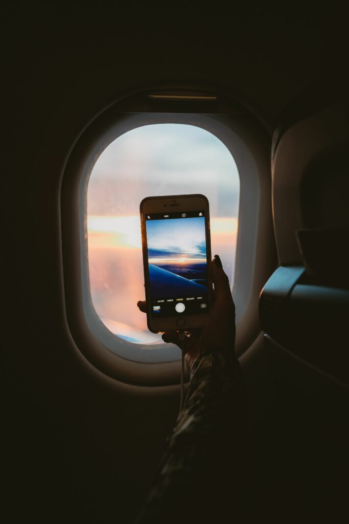 Dreamy Airplane Window Wallpaper: Phone Captures Serene Landscape