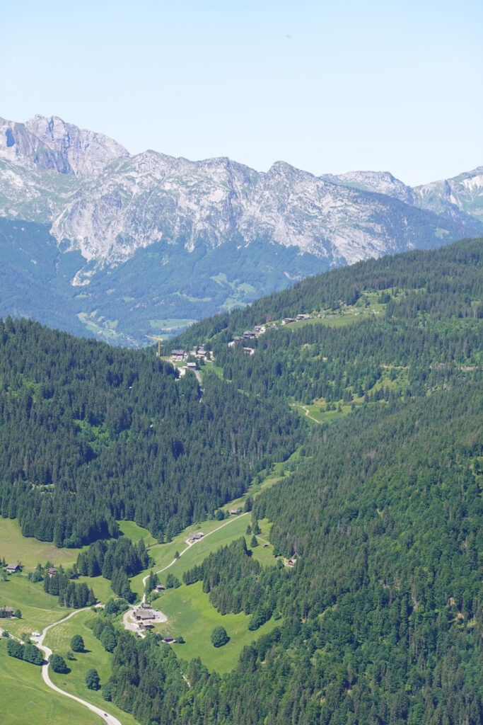 Majestic mountains with rugged peaks above green forests winding trail and lush valley scenery Wallpaper