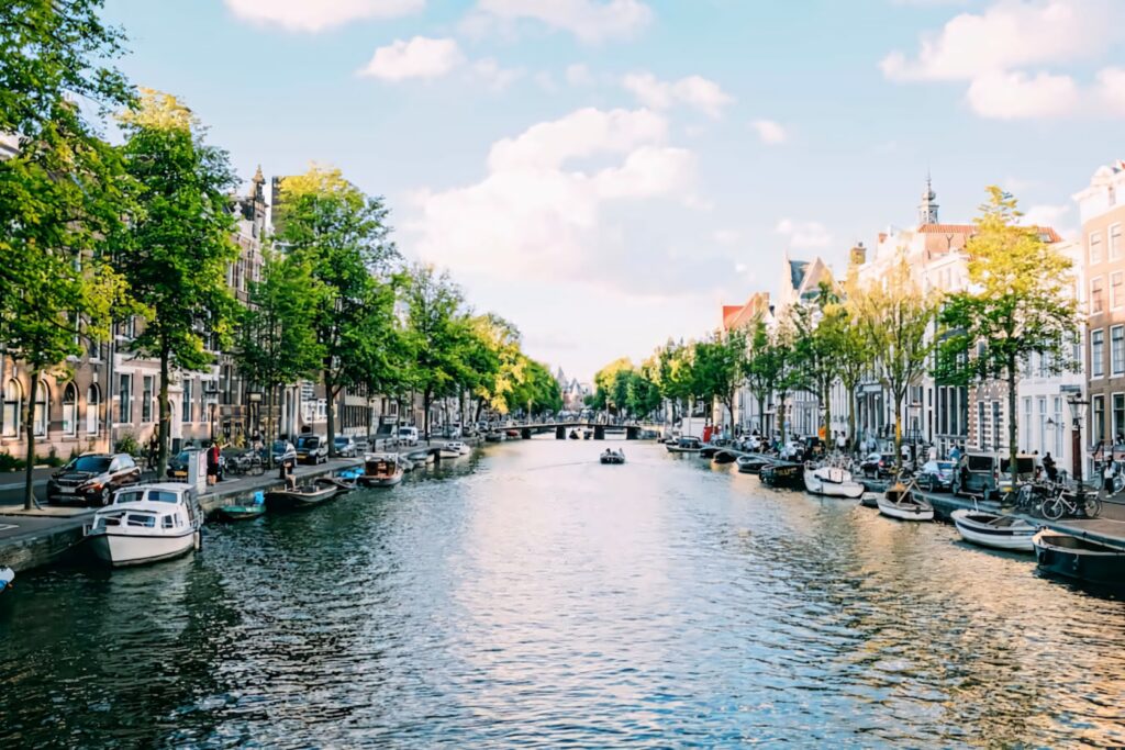 Serene Amsterdam Canal Wallpaper: Charming Architecture & Lush Greenery