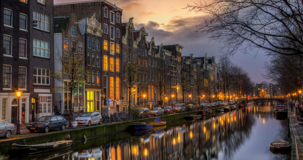 Serene Amsterdam Evening: Illuminated Canals & Charming Reflections Wallpaper