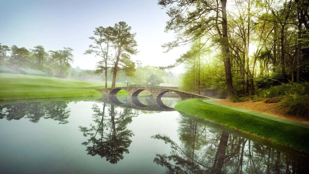 Serene Augusta National Golf Course stone bridge over reflective river with lush greenery wallpaper