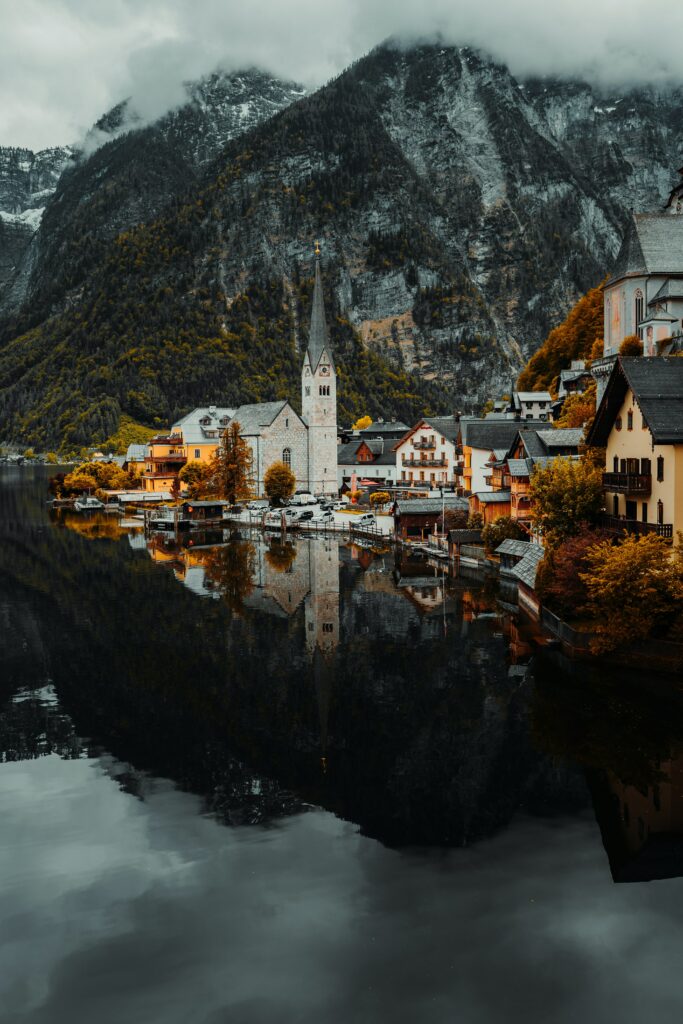 Aerial view of colorful lakeside village with mountain backdrop in serene autumn colors wallpaper