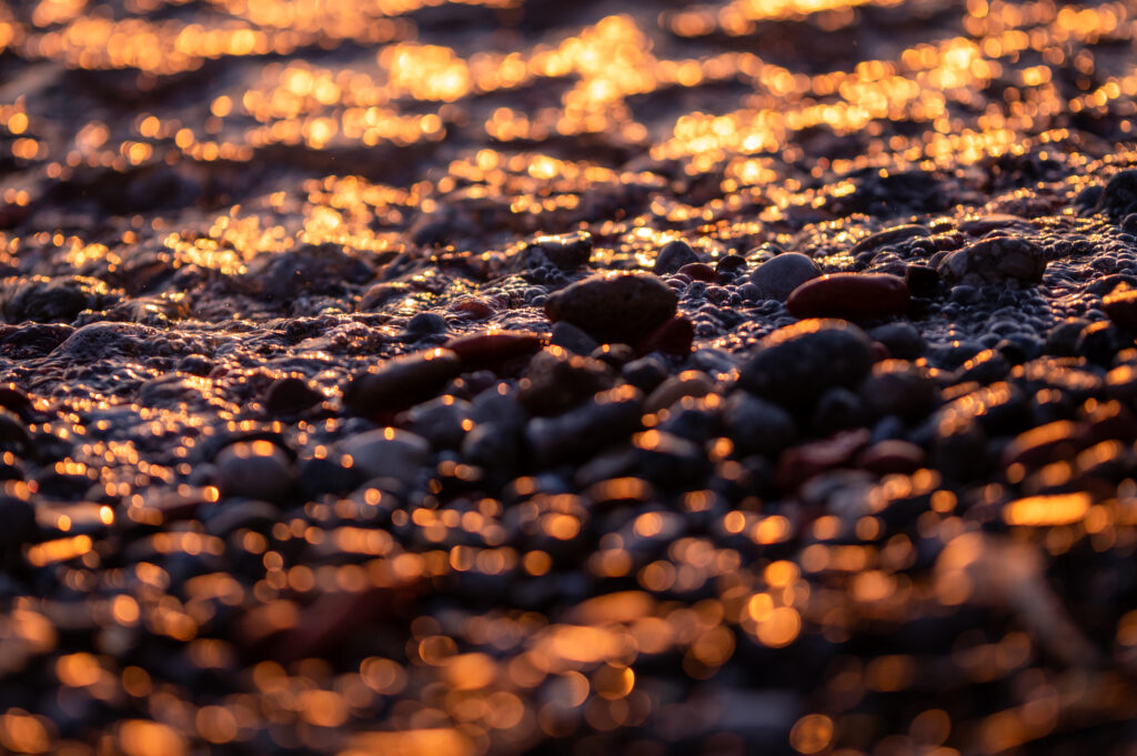 Serene Beach Pebbles: Sunlit Close-Up Wallpaper Background