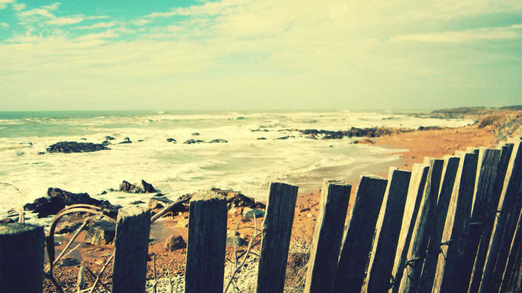 Serene Vintage Beach Wallpaper Over Rustic Fence - Tranquil Scene
