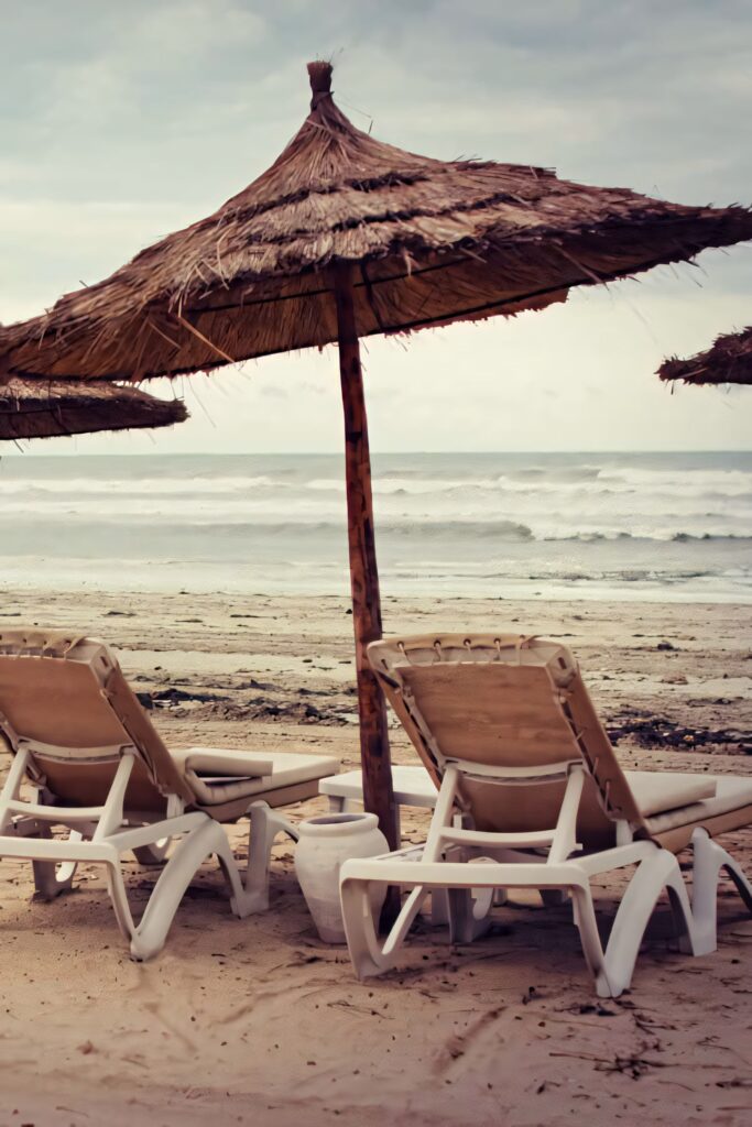 Tranquil Beach Scene: Reclining Chairs & Thatched Umbrellas Wallpaper