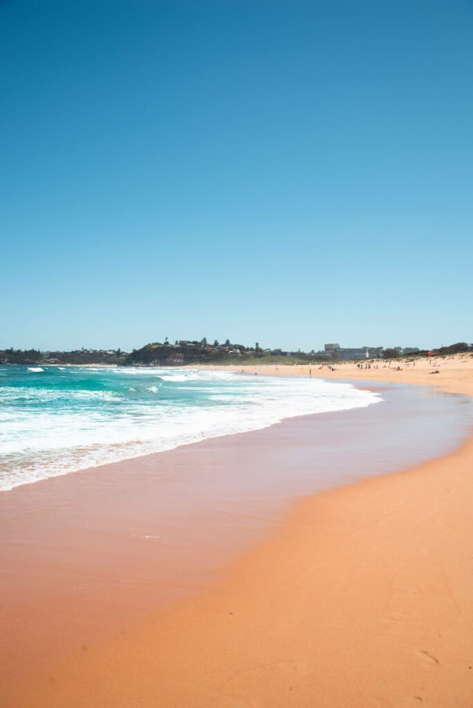 Serene Beach Scene Wallpaper: Smooth Sandy Shore & Vibrant Sky