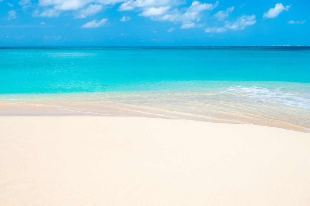 Tranquil Beach Scene: Smooth Sand & Vibrant Turquoise Waters Wallpaper