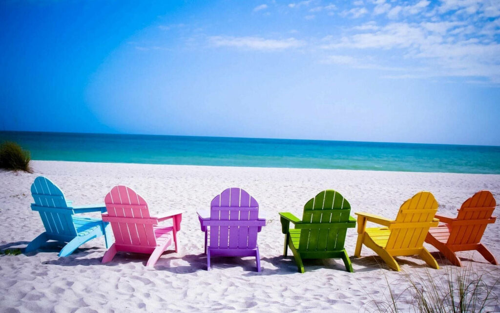 Colorful Beach Chairs on Pristine Sand: Joyful Ocean Escape Wallpaper
