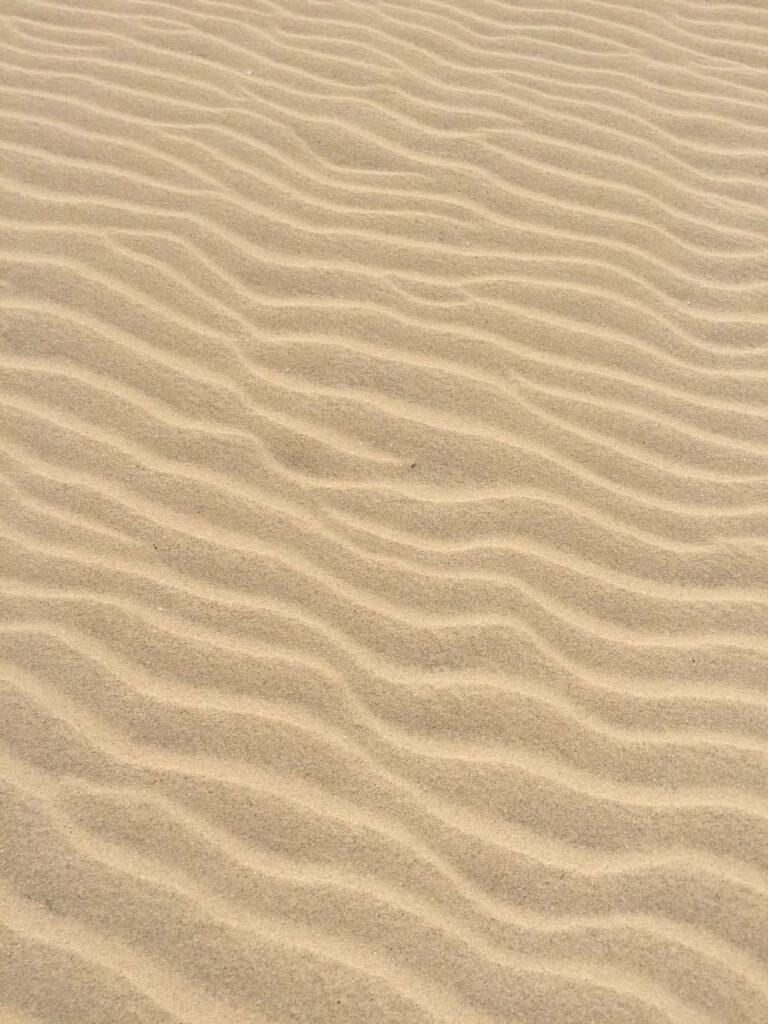 Serene Beach Wallpaper: Close-Up of Rippled Sand & Wave Textures