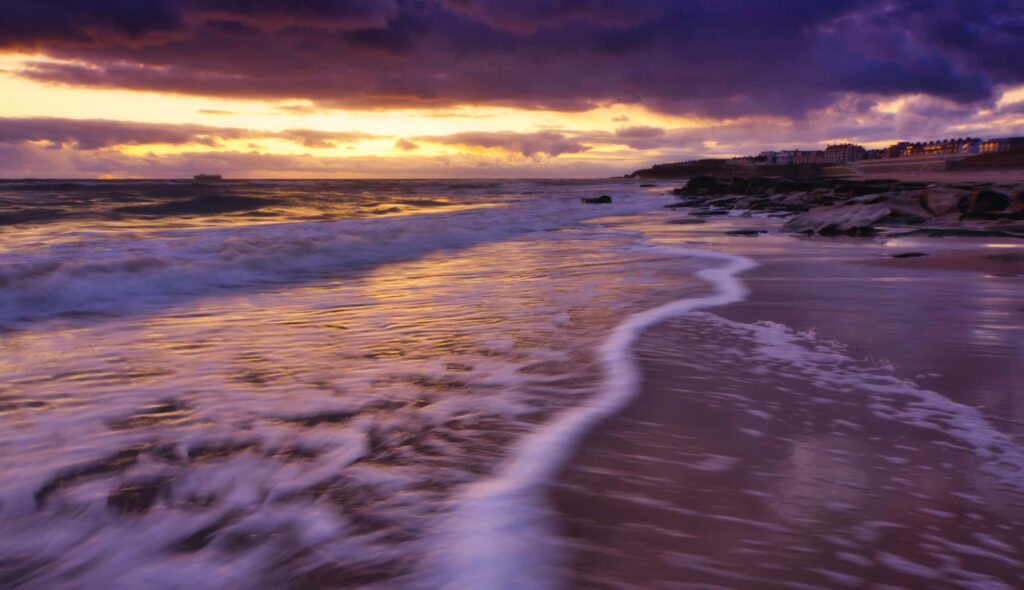 Serene Beach Sunset Wallpaper: Gentle Waves & Vibrant Sky Background