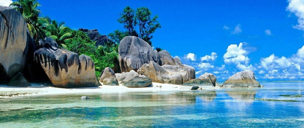 Tranquil Beach Wallpaper: Lush Greens & Rock Formations Beauty
