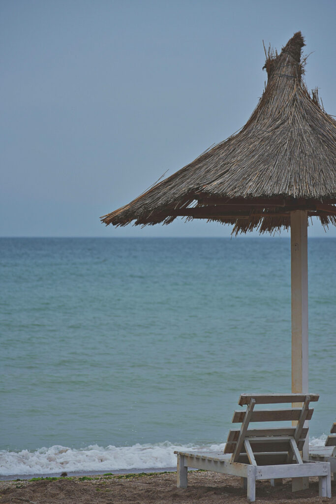 Tranquil Beach with Rustic Chair & Thatched Hut - Perfect Android Wallpaper
