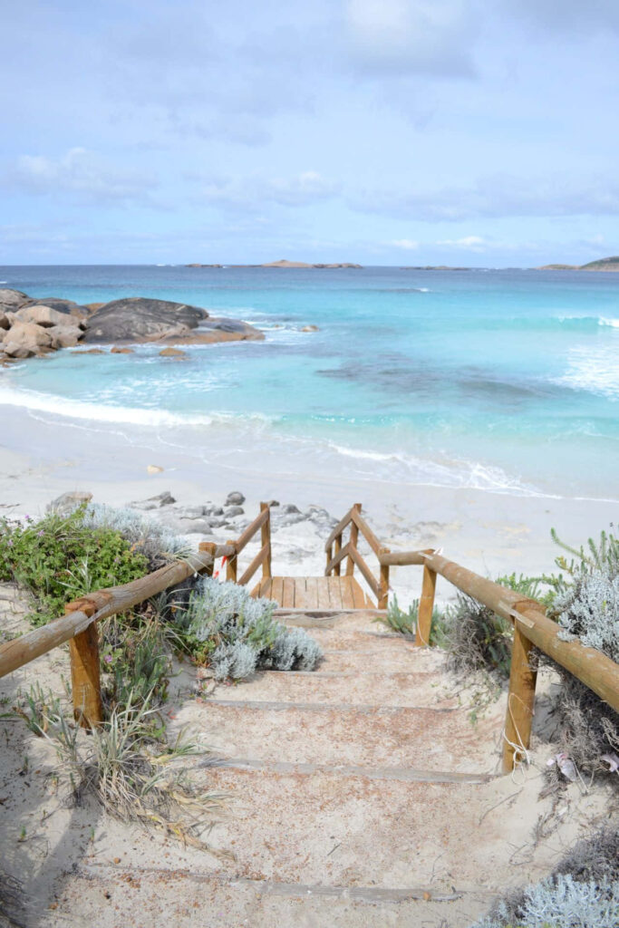 Serene Beach Wallpaper: Turquoise Waters & Rustic Staircase