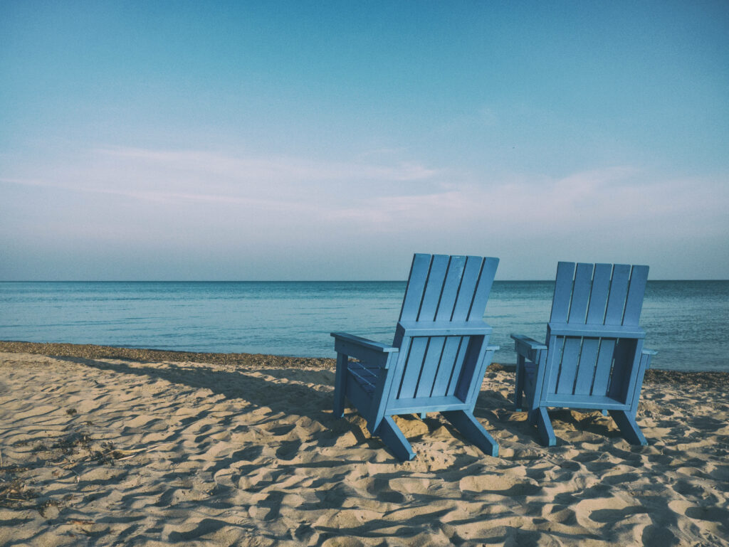 Serene Beach Chairs on Sandy Shore - Calming Ocean Wallpaper