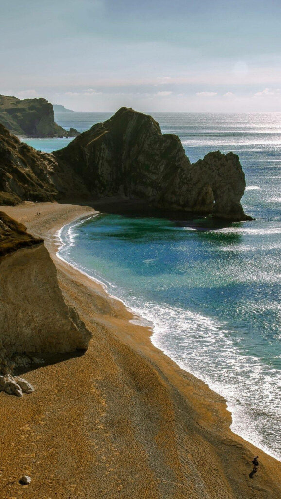 Serene Beach Waves & Cliffs: Perfect New Phone Wallpaper Background