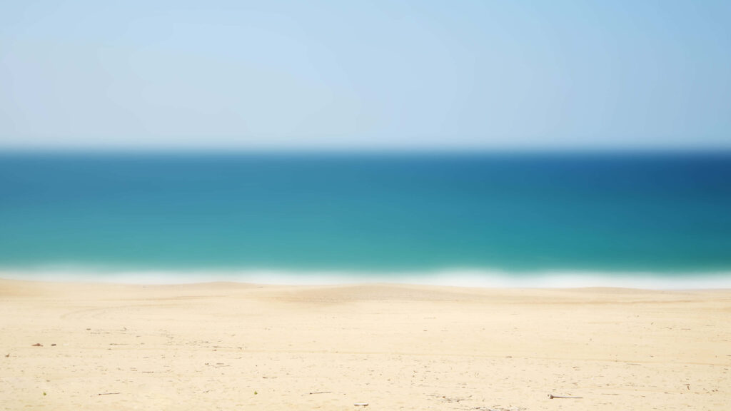 Serene Beachscape Wallpaper: Sandy Shore & Tranquil Ocean Background