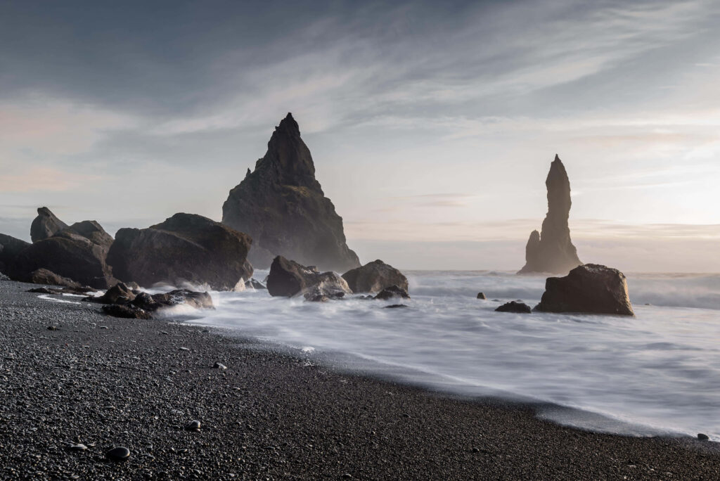 Serene Black Sand Beach Wallpaper with Dramatic Rock Formations