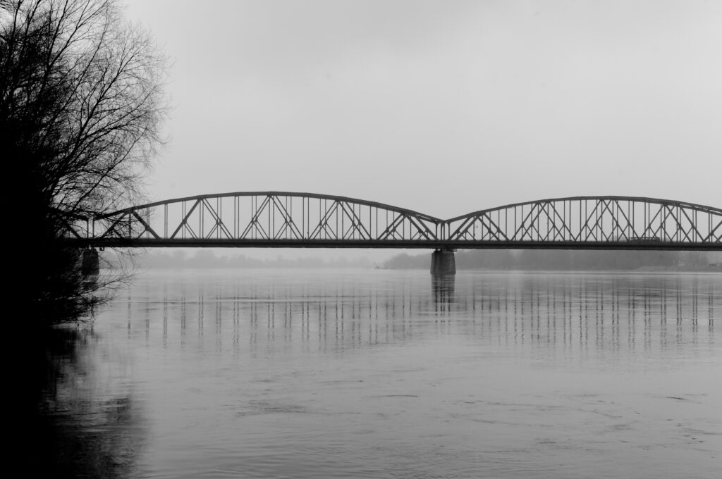Serene Black-and-White Riverscape Wallpaper with Arched Bridge