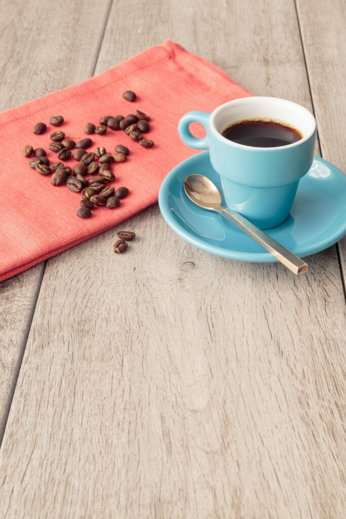 Serene Wallpaper: Blue Coffee Cup with Beans on Wooden Surface