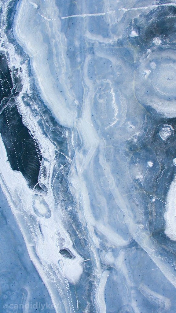 Serene blue frozen ice close-up with intricate frost patterns abstract nature wallpaper background